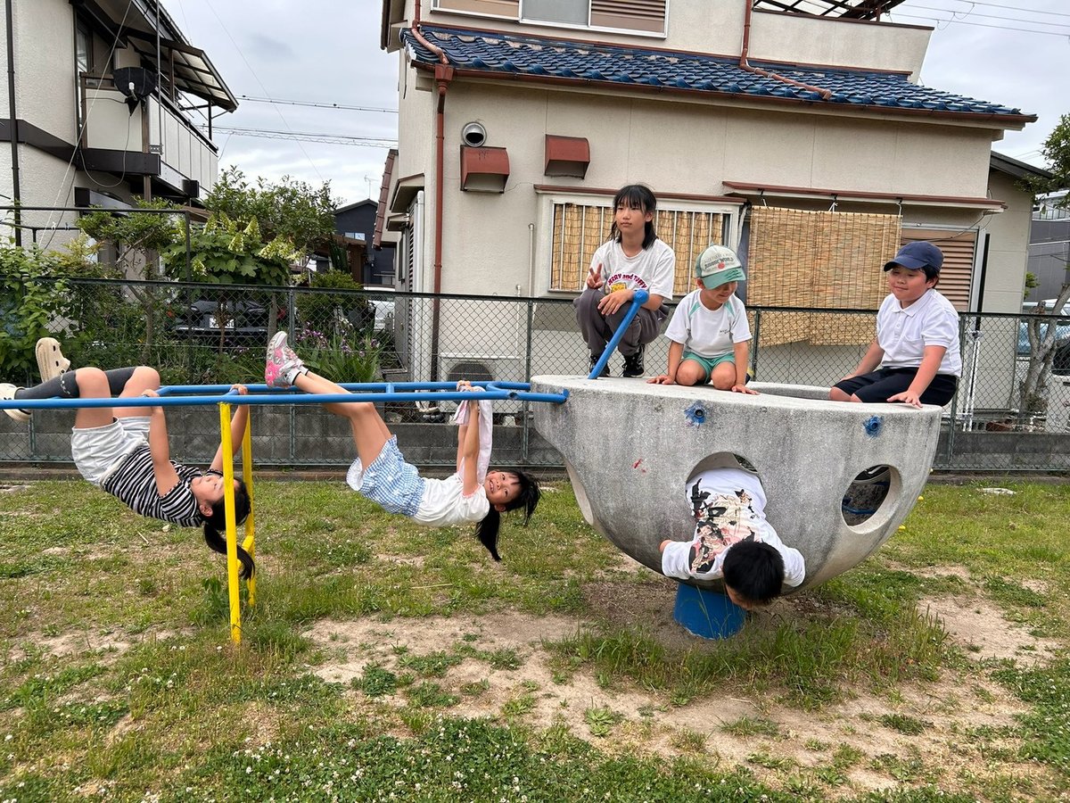 公園レッスンで遊具にぶら下がる子どもたち