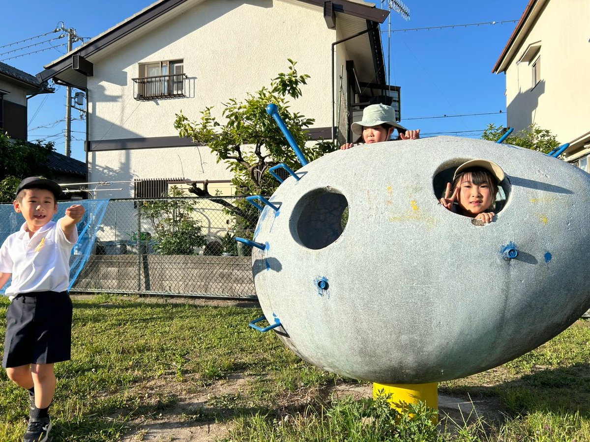 公園の遊具から顔を出す子ども