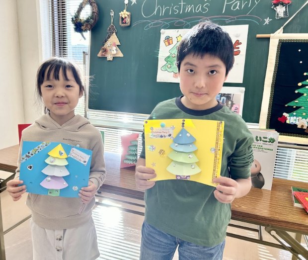 クリスマス会で作ったカードを見せる子どもたち
