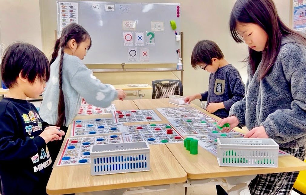 大きなカルタのシートを囲む加古川教室のレッスン
