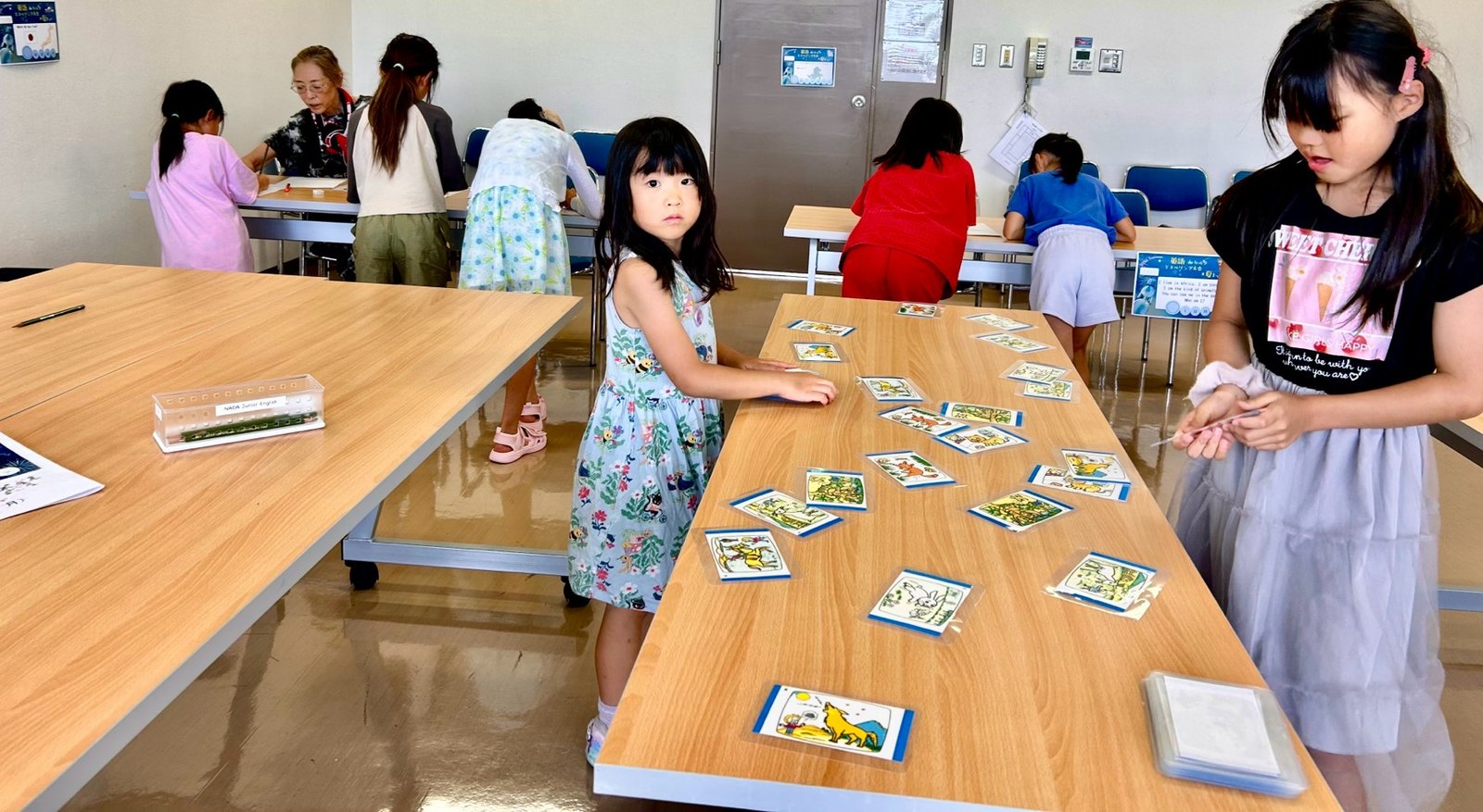 長い机に広げたカードで学ぶ教室のレッスン