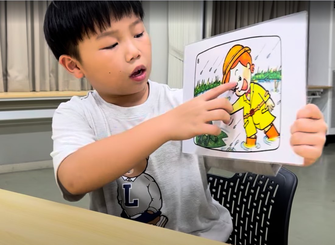 絵カードを指さして英語で話す男の子